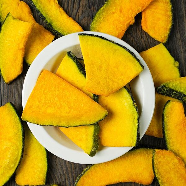 Vacuum fried pumpkin slices flat lay display, vivid orange slices in natural shapes