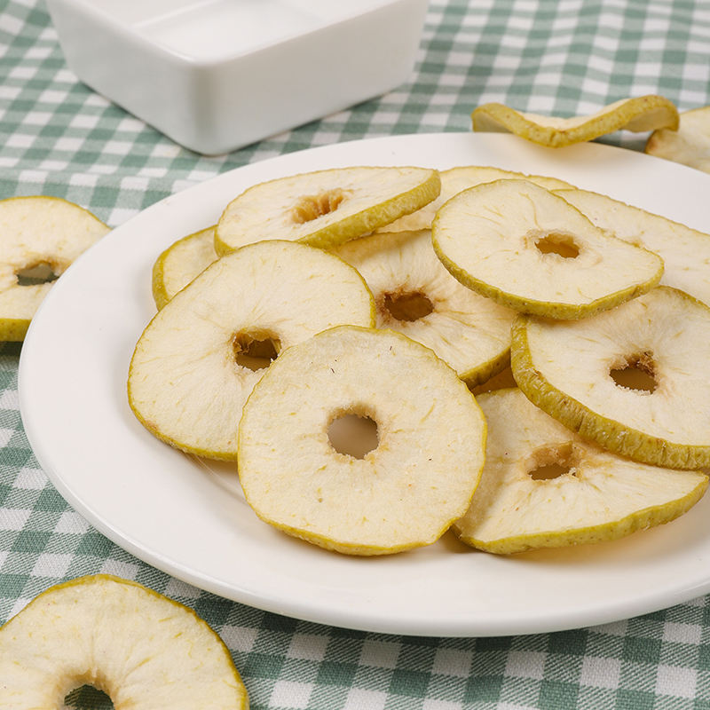 Vacuum fried green apple slices stack display, thin crispy slices with visible green edges