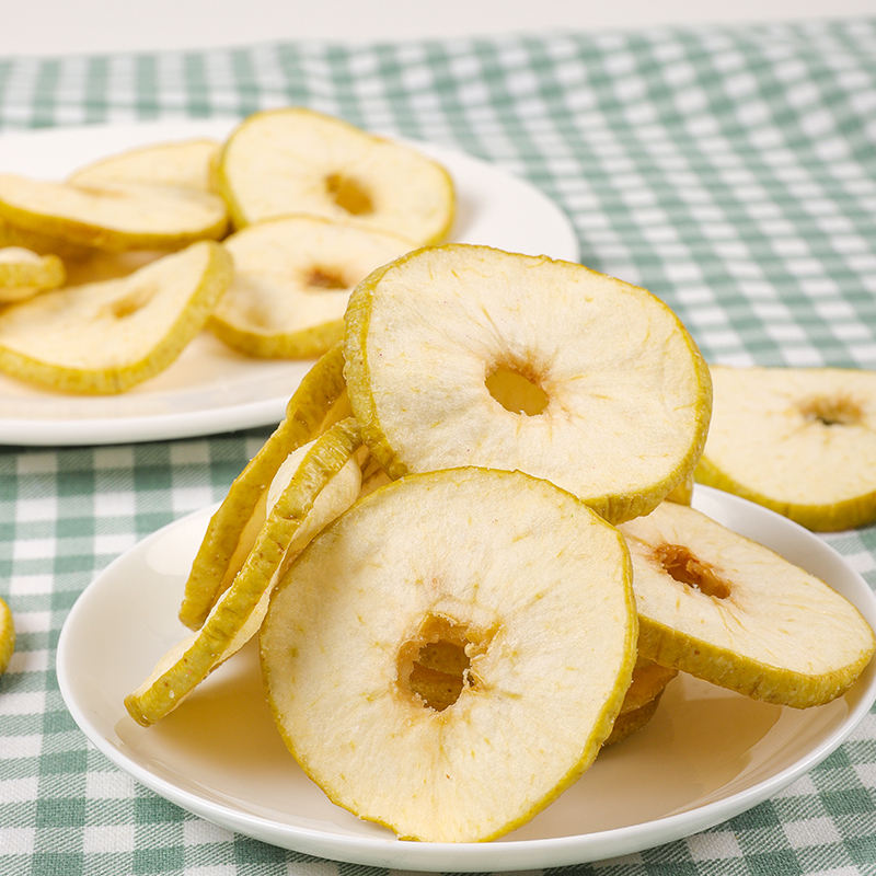 Vacuum fried green apple slices flat lay display, abundant cream slices with green edges