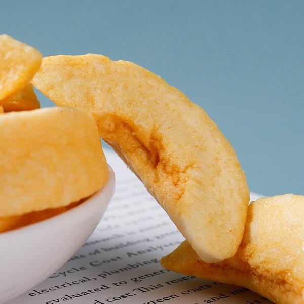 Vacuum fried yellow peach slice close up, natural golden color and crispy texture detail